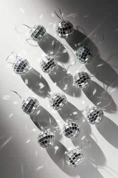 several shiny disco balls are arranged in the shape of a ball on a white surface