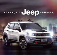 the jeep compass is parked in front of a cityscape