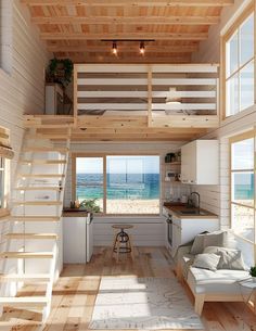 a living room filled with furniture next to a kitchen and an open door leading to the beach