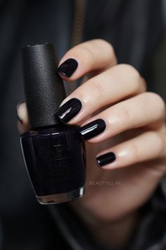 a woman with black nail polish holding onto her hand