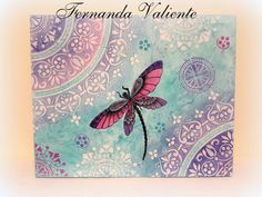 a card with a pink dragonfly on it's back and paisley designs in the background