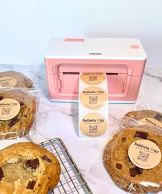 some cookies are cooling on a rack next to a pink toaster oven and other baking supplies