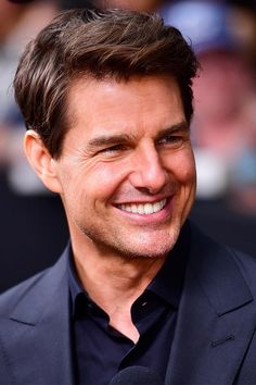 a close up of a person wearing a suit and smiling