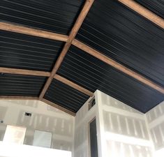 the inside of a room with black and white paint on the walls, wood ceilinging