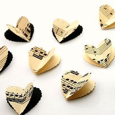 several pieces of music paper with musical notes on them, arranged in the shape of hearts