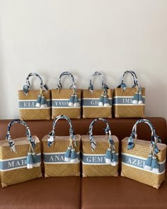 six woven bags with names on them sitting on a couch