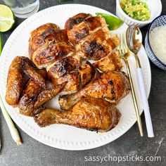 grilled chicken wings on a plate with dipping sauce and lime wedges next to it