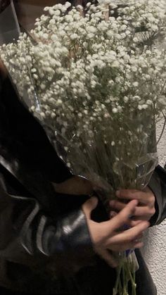 a woman holding a bouquet of white flowers