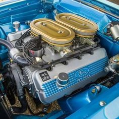 the engine compartment of an older model ford mustang with gold rims and blue paint