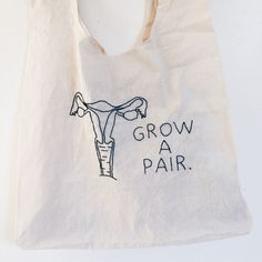 a tote bag with an image of a woman's torso and the words grow a pair on it