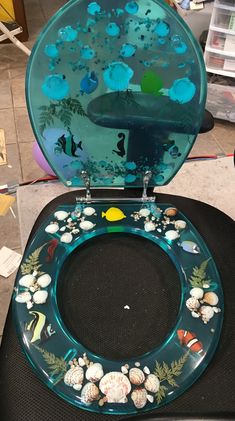 the toilet seat is decorated with sea shells and marine life, as well as an underwater scene