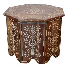 an octagonal wooden table with carved designs on it