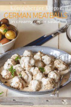 a bowl filled with meatballs covered in gravy next to other food items