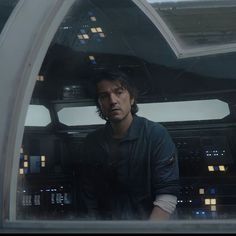 a man standing in front of a window looking at the camera while wearing a star wars uniform