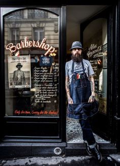 a man standing in front of a barber shop