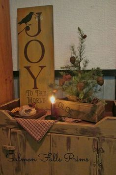 a candle is lit in front of a wooden box with joy to the world written on it