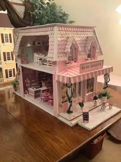 a pink doll house on top of a wooden table