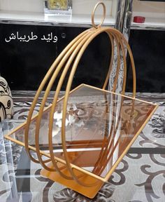 a glass and metal birdcage sitting on top of a table