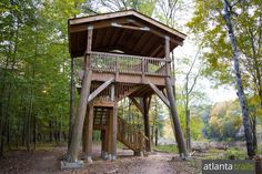 a tree house in the woods with stairs leading up to it