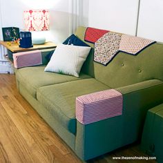 a green couch with colorful pillows on it