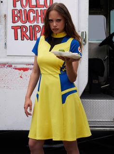 a woman in a yellow and blue dress holding a plate