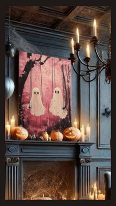 a fireplace decorated for halloween with candles and ghost pictures on the mantel above it