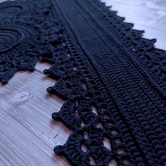 black crocheted lace on wooden floor with white background