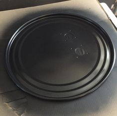 a black plate sitting on top of a cardboard box