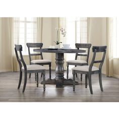 a dining room table with four chairs around it