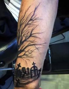 a man's arm with a cross and tree tattoo on the left side of his arm