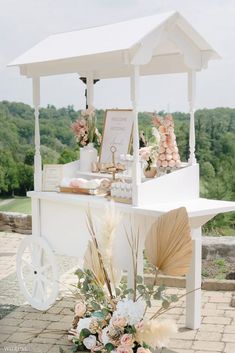 a white table with flowers and other items on it