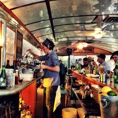 the bartenders are preparing their drinks at the bar in the restaurant's dining car