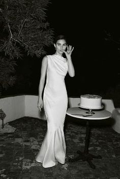 a woman standing next to a table with a cake on it