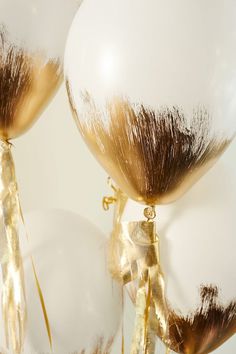 an image of two balloons that are gold and brown with some hair on top of them