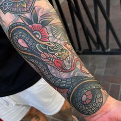 a man's arm with a dragon tattoo on it and an eyeball in the middle