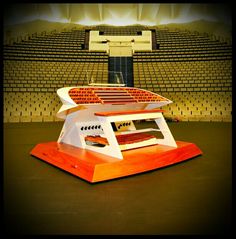 a table that is sitting in front of an empty stage with rows of seats behind it