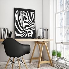 a black and white zebra print hangs on the wall next to a desk with two chairs