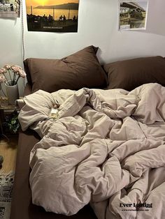 an unmade bed in a bedroom with brown sheets and blankets on top of it