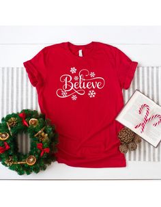 "Believe Shirt, Christmas Shirt, Christmas Believe Tee, Believe T-Shirt, Believe Shirt Gift, Believe TShirt,Believe Red,Merry Christmas Shirt ☀️☀️☀️☀️☀️ Everything in our shop is hand crafted and made to order. If you want different color or size contact me! If you would like something custom made to fit your personal style please message me and I will do everything to get you that something special. ---How To Order--- ⭐️Please, check and review all photos ⭐️Choose your t-shirt size and color ⭐️ Season Decorations, Christmas Believe, Dinosaur Gifts, Christmas Tshirt, Merry Christmas Shirts, Birthday Party Shirt, Custom Printed Shirts, Grinch Christmas, Decorations Christmas