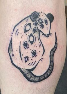 a black and white tattoo on the leg of a man with a rat in it