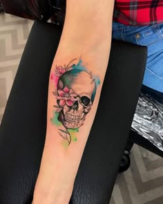 a woman's arm with a skull and flower tattoo on the left side of her leg