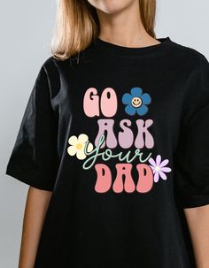 a woman wearing a black t - shirt that says go ask your dad on it