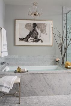 a bathroom with a marble tub and chandelier