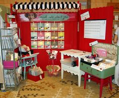 a room filled with lots of different types of furniture and decor on display in front of a red wall