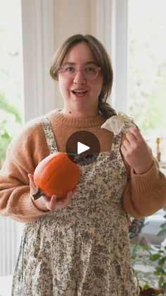 a woman is holding an orange in her hands