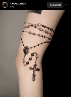 a woman's arm with rosary tattoos on it