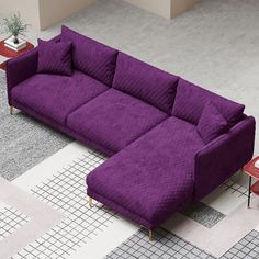 a purple couch sitting on top of a white floor next to a table and chair