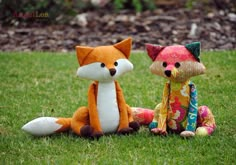 two stuffed animals are sitting in the grass