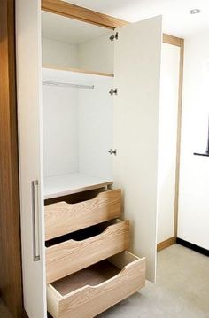 an open closet door with drawers in it