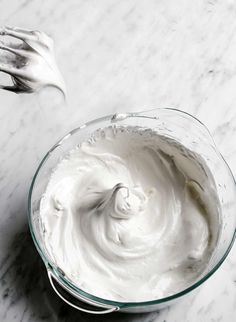 whipped cream in a glass bowl on a marble surface